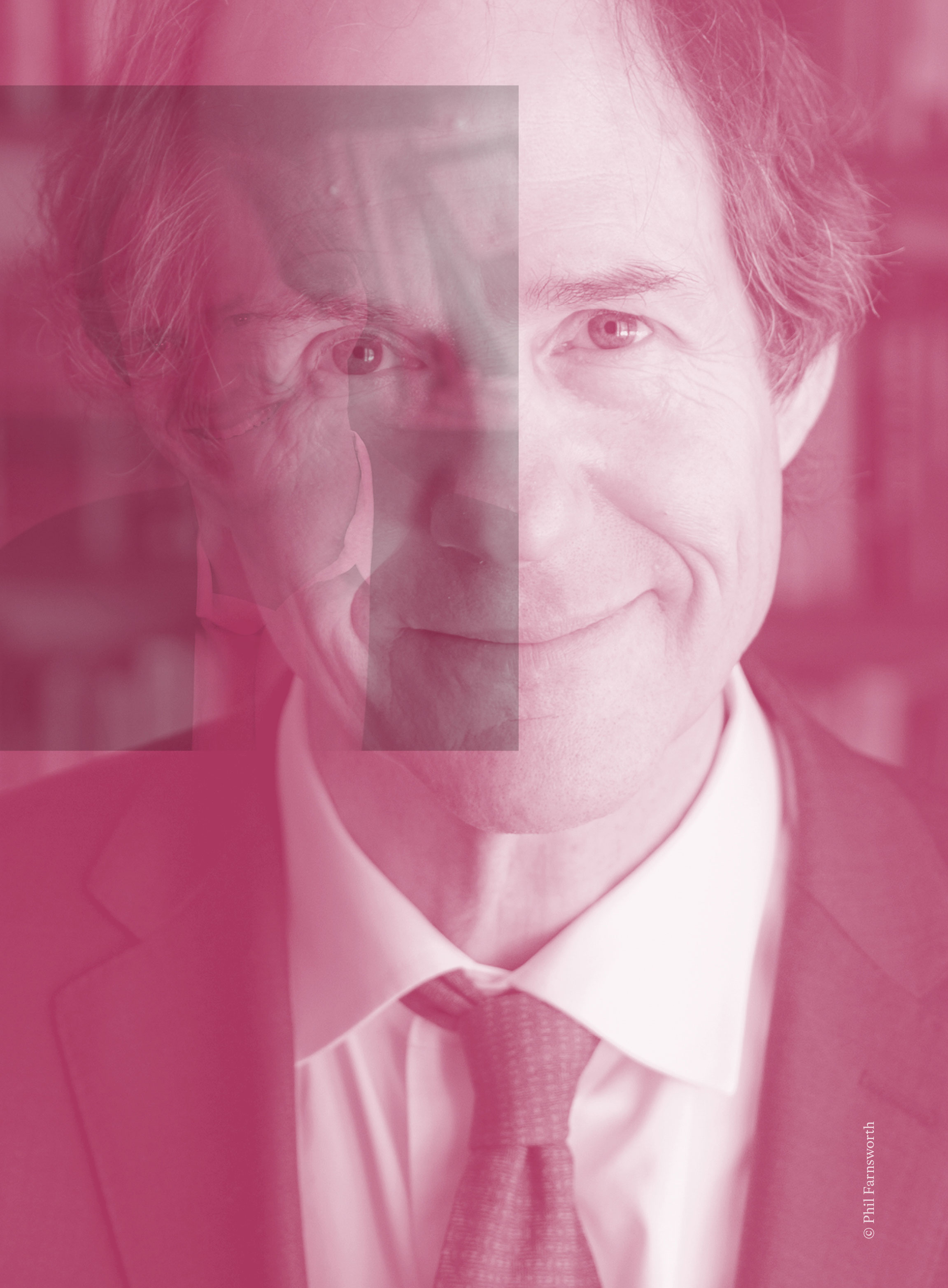 A man in a suit and tie smiles slightly at the camera. The image has a pink overlay with a translucent square partly covering his face. The background shows blurred shelves, possibly books.