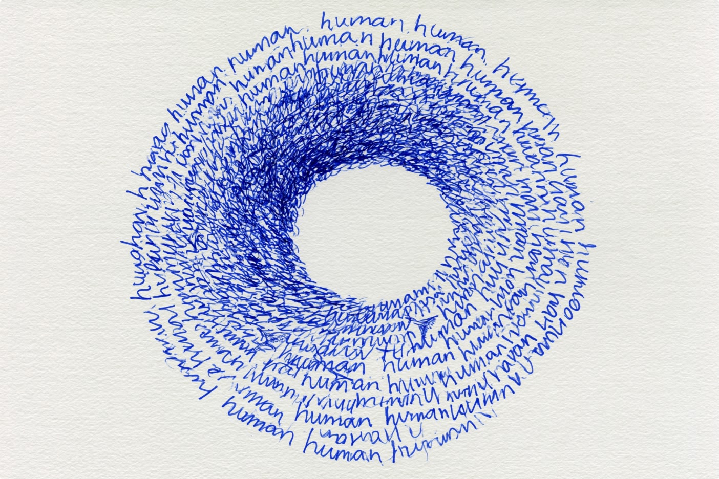 Handwritten word "human" repeatedly forms a circular pattern in blue ink on white paper, creating a dense ring with an empty center. The writing is looser on the outer edge and densely packed toward the middle.