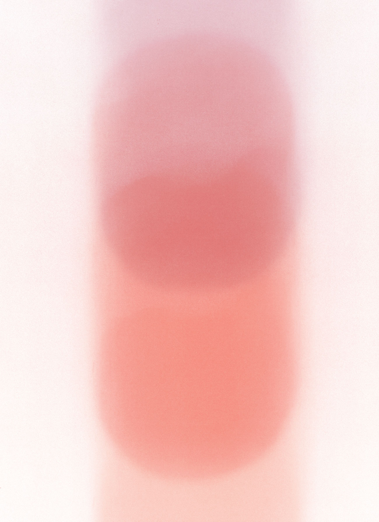 Soft, abstract image with two overlapping, blurred pinkish-red ovals on a light background, creating a gentle gradient effect.